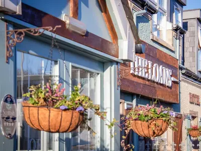 two flowerpots hanging on the side of a building at The Loans Inn Cottage in Loans