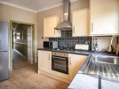 a kitchen with a sink and a stove top oven at The Loans Inn Cottage in Loans