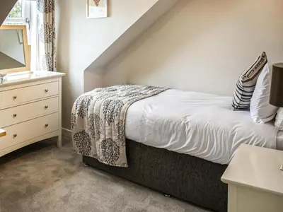 a bedroom with a bed and a dresser with a mirror at The Loans Inn Cottage in Loans