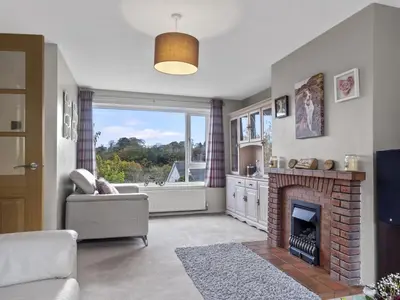 a living room with a fireplace and a window at Finest Retreats - Willow Dene in Cockermouth
