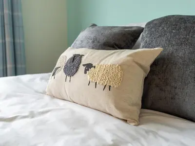 a pillow with animals on it sitting on a bed at Finest Retreats - Willow Dene in Cockermouth