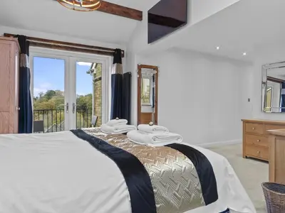a bedroom with a bed and a large window at Finest Retreats - Willow Dene in Cockermouth