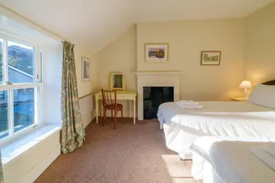 a bedroom with two beds and a window and a desk at 7 Low Glenridding - with private parking in Glenridding