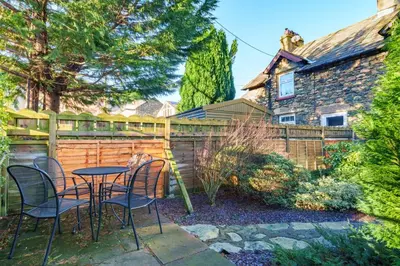 a patio with a table and chairs in front of a fence at 7 Low Glenridding - with private parking in Glenridding