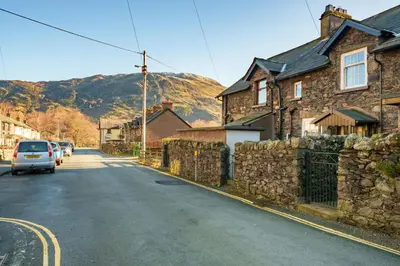 a car driving down a street with a stone wall at 7 Low Glenridding - with private parking in Glenridding