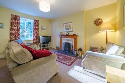 a living room with two couches and a fireplace at 7 Low Glenridding - with private parking in Glenridding