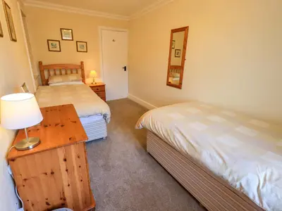a bedroom with two beds and a table with a lamp at Lakeland View Lodge in Keswick
