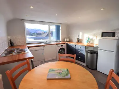 a kitchen with a wooden table and a kitchen with a window at Lakeland View Lodge in Keswick