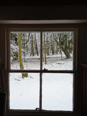 a window with a view of a snow covered yard at The Dairy - Patterdale Hall in Penrith