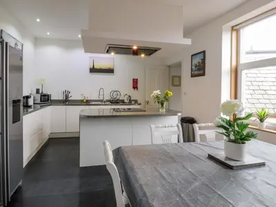 a kitchen and dining room with a table and a kitchen and a dining room at Ailsa View in Girvan