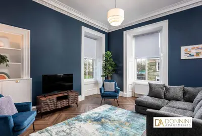 a living room with blue walls and a tv at The Oliver in Ayr