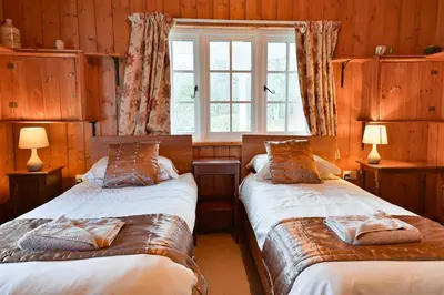 two beds in a room with a window at Garlies Lodge in Bargrennan