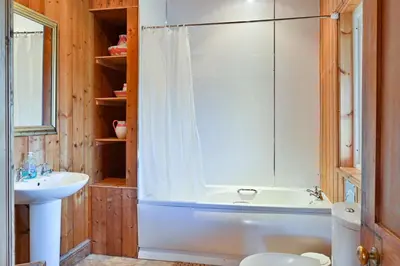 a bathroom with a shower and a tub and a sink at Garlies Lodge in Bargrennan
