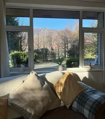 a living room with a couch and a window at Maiden Moor in Borrowdale Valley