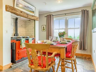 a dining room with a table and chairs and a stove at 3 Bed in Keswick oc-sz080 in Braithwaite