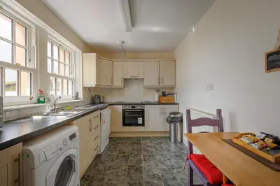 a kitchen with white cabinets and a wooden table at 3 Bed in Drummore oc-p30213 in Drummore