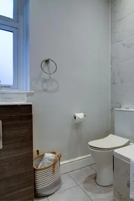 a white bathroom with a toilet and a sink at The Fullarton - Coorie Doon Stays in Troon