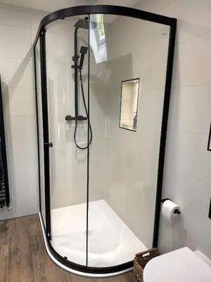 a shower with a glass door in a bathroom at Field Apartment in Douglas