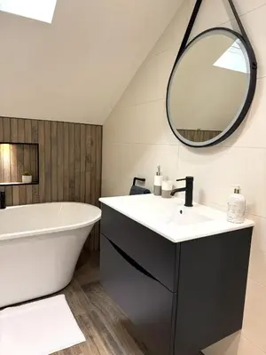 a bathroom with a tub and a sink and a mirror at Field Apartment in Douglas