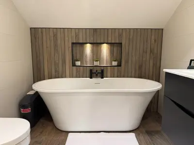 a white bath tub in a bathroom with a toilet at Field Apartment in Douglas