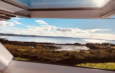 a view of a lake from a window at Curlew Cottage in Gatehouse of Fleet