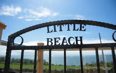 a metal gate with the words little beach on it at Little Beach in Gatehouse of Fleet