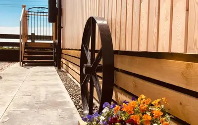 a fence with a bunch of flowers next to a gate at Little Beach in Gatehouse of Fleet