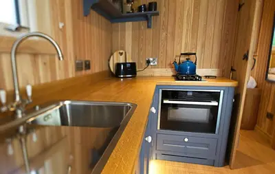 a kitchen with a stove and a blue tea kettle at Little Oak in Gatehouse of Fleet