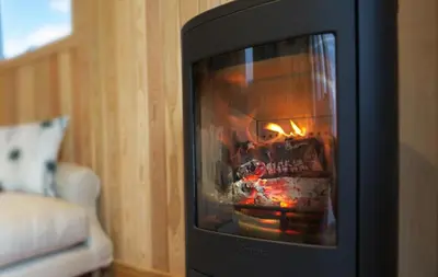 a fireplace in a living room with a fire in it at Little Oak in Gatehouse of Fleet