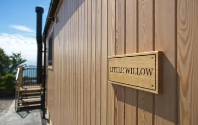 a wooden sign on the side of a building at Little Willow in Gatehouse of Fleet