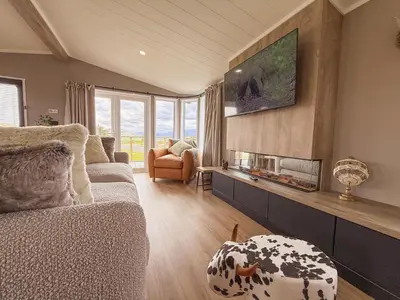 a living room with a couch and a fire place at Dogwood Lodge in Bassenthwaite