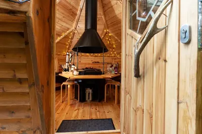 a kitchen with a table in a wooden cabin at Scenery Hill Hideaways The Coach House Charming Retreat with Jacuzzi and BBQ Hut Near the Lake District in Workington