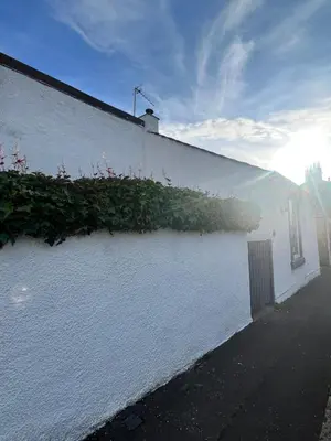 a white building with plants on the side of it at Kennedy Cottage by Troon beach in Troon