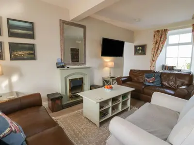 a living room with a couch and a fireplace at Arthur's Cottage in Dumfries