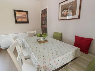 a dining room with a table and chairs with a tableablish at Arthur's Cottage in Dumfries