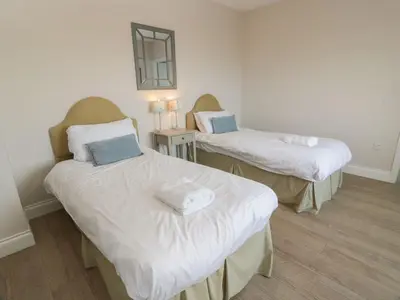 a room with two beds and a mirror at Arthur's Cottage in Dumfries