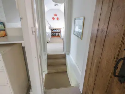 a hallway with stairs leading up to a house at Powillimount Cottage in Dumfries