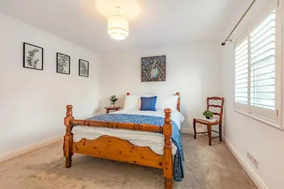 a bedroom with a wooden bed and a window at 3 Bed in Longtown oc-h30069 in Longtown