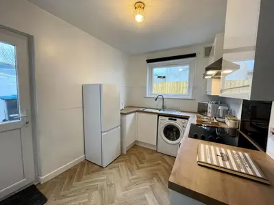 a kitchen with a refrigerator and a washing machine at Beautifully Presented Cosy Town Centre Cottage - Pass the Keys in Dumfries