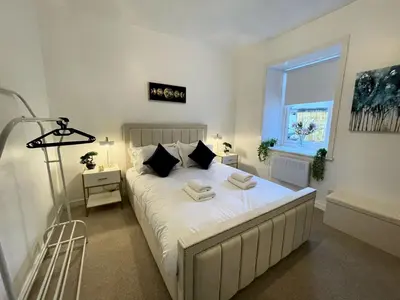 a bedroom with a bed with two towels on it at Beautifully Presented Cosy Town Centre Cottage - Pass the Keys in Dumfries