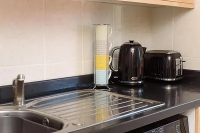 a kitchen counter with a sink and a coffee maker at Mulberry Cottage in Whithorn