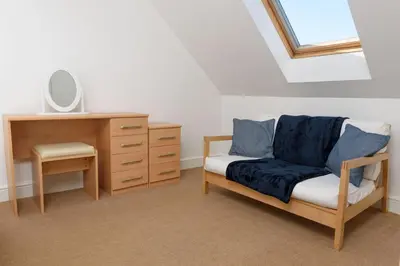 a bedroom with a desk and a chair and a dresser at Mulberry Cottage in Whithorn