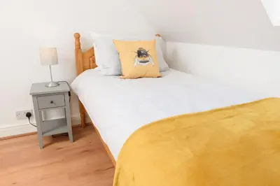 a bedroom with a bed with a dog pillow on it at Mulberry Cottage in Whithorn