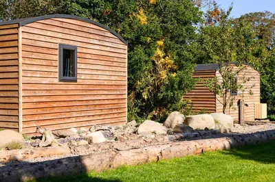 a small wooden building next to a pile of rocks at Rowan in Whithorn