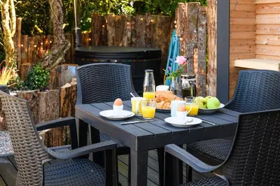 a wooden table with food and drinks on a patio at Rowan in Whithorn