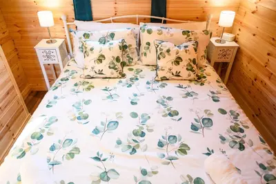 a bed with a floral bedspread and pillows at Ivy in Whithorn