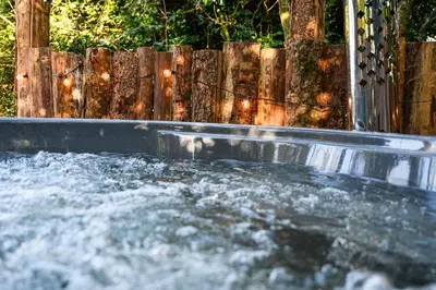 a plunge pool with water in front of a wooden fence at Ivy in Whithorn