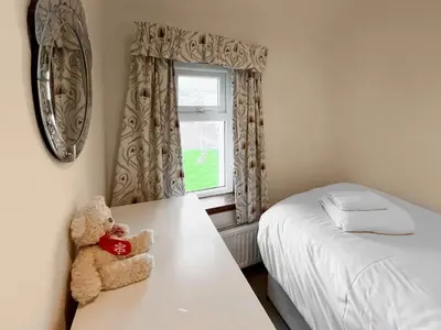 a teddy bear sitting on a table in a bedroom at South Haven in Portpatrick