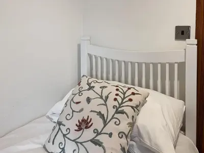 a white bed with a pillow on it at South Haven in Portpatrick