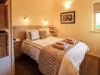 a bedroom with a bed with two pillows on it at Larch Lodge in Penrith